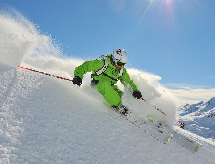 Skifahrer bei Abfahrt im Pulverschnee